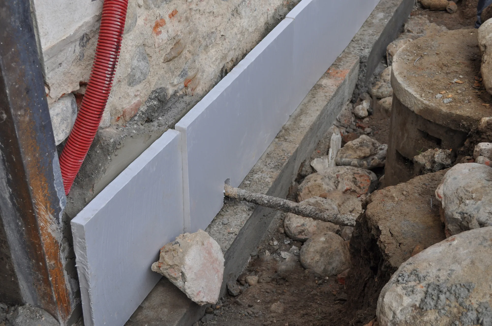 Boards and steel reinforcement set against an excavated house footing during underpinning